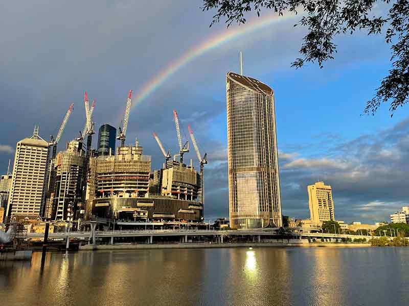 Building near to lake with rainbow behind