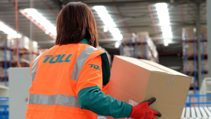 A lady worker picking up a boxes in the industrial area