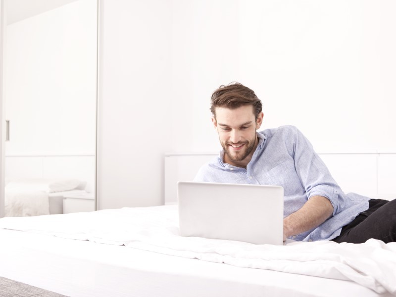 Man working on Laptop in hotel room during pandemic