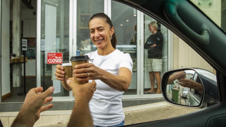 women serving customer outside coffee shop