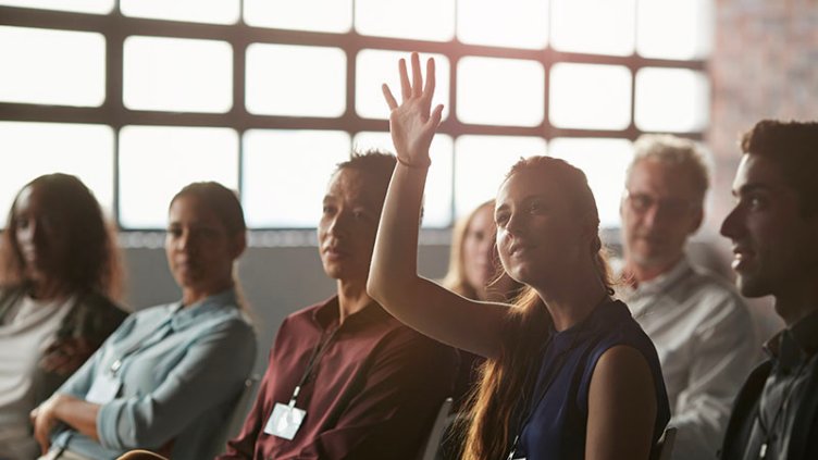 Girl raised her hand from the group of people