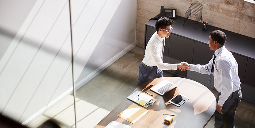 Two people shake hands in an office 