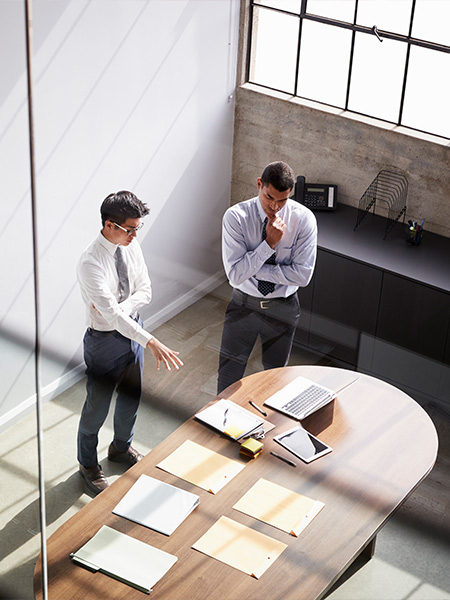 Two men discussing inside the conference room