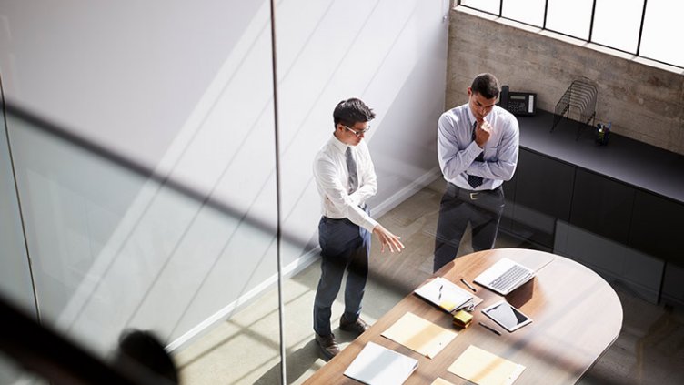 Two men discussing inside the conference room