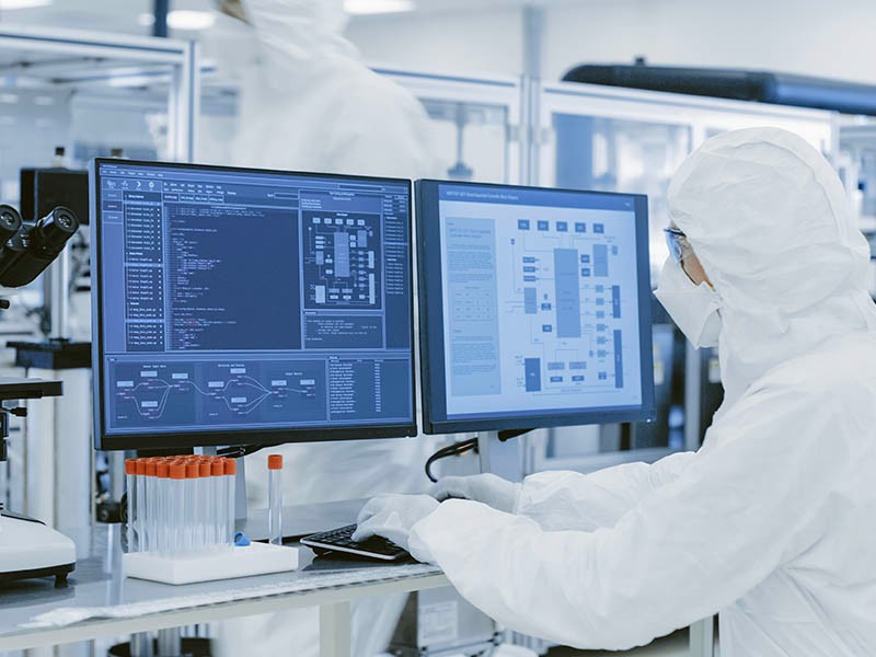 Life sciences researcher wearing mask and analyzing the research reports in the medical laboratory