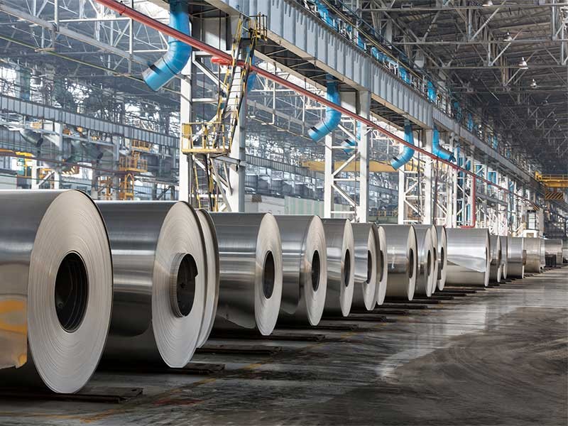 Row of rolls of aluminum lie in production shop of plant