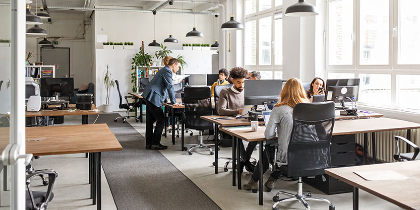 Business people working at desks. Male and female professionals working in modern office space.