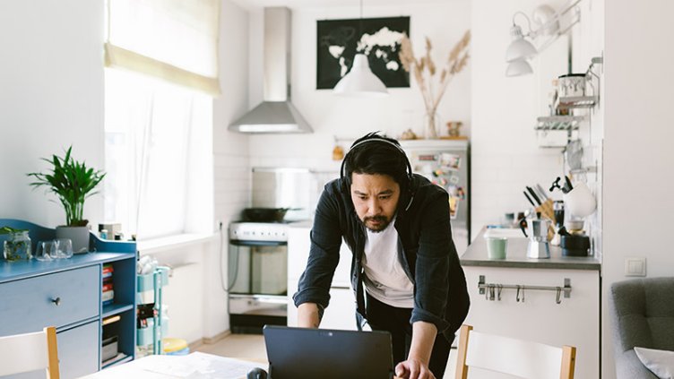 Adult man telecommuting in home office