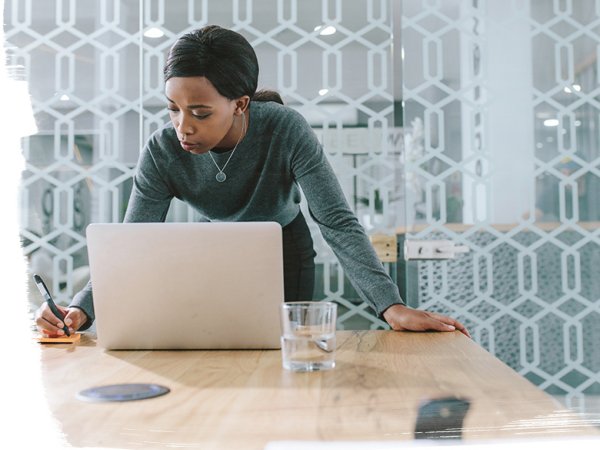 woman working on laptop at home office desk