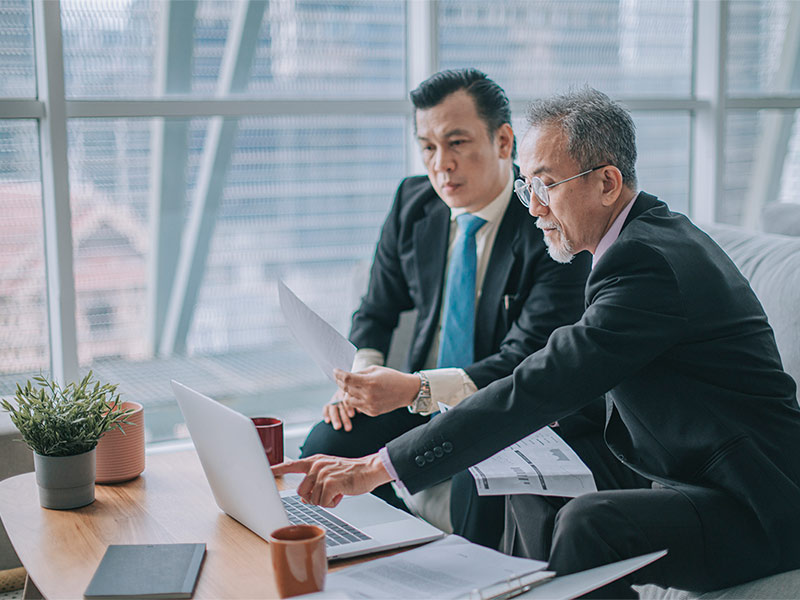 Two employees looking into a laptop