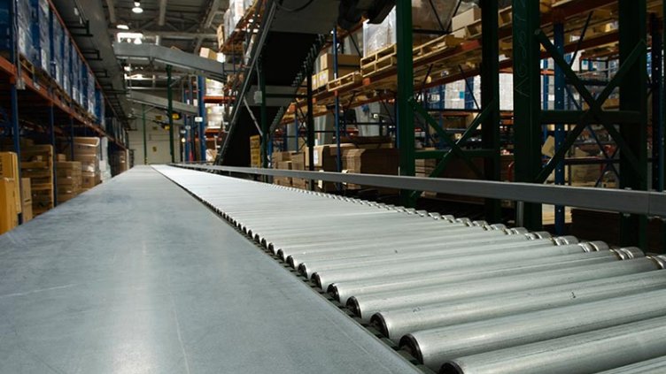 A warehouse conveyor belt loaded with numerous boxes ready for sorting and distribution.